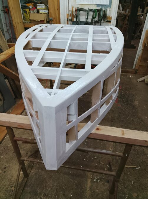 Waterproof name stickers being layered one over the other across the boat frame