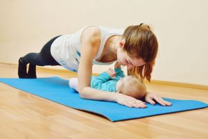 54833837 - young mother does physical yoga exercises together with her baby