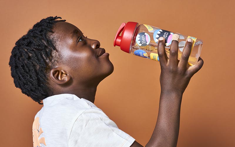 Boy holding a water bottle with name stickers from My Nametags