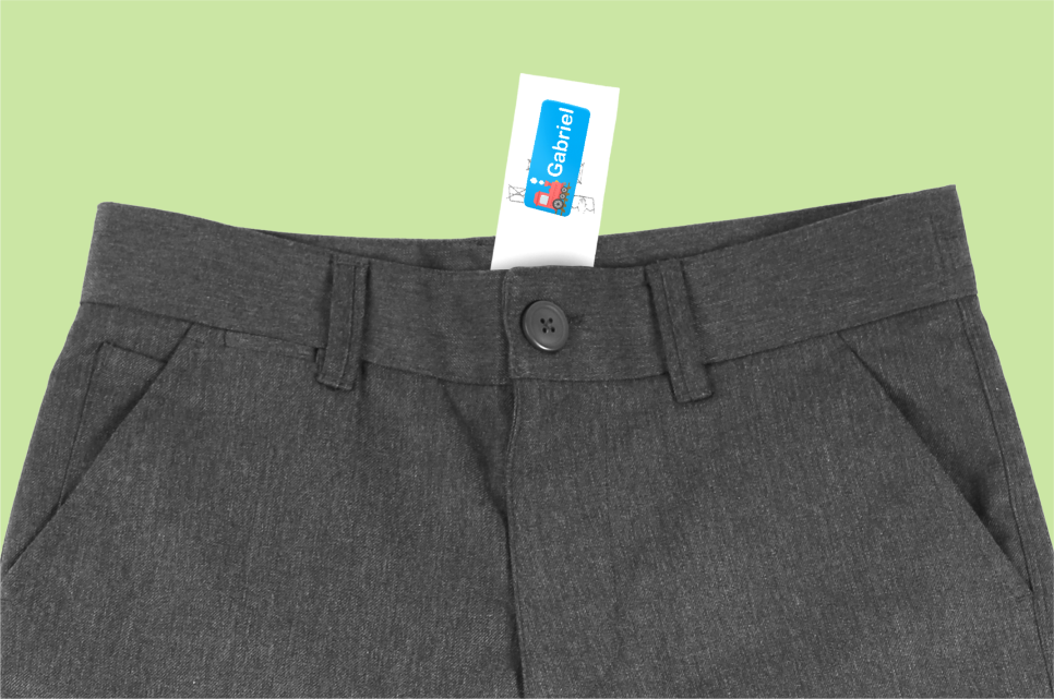 Dark grey school shorts with a blue name label on the care label.