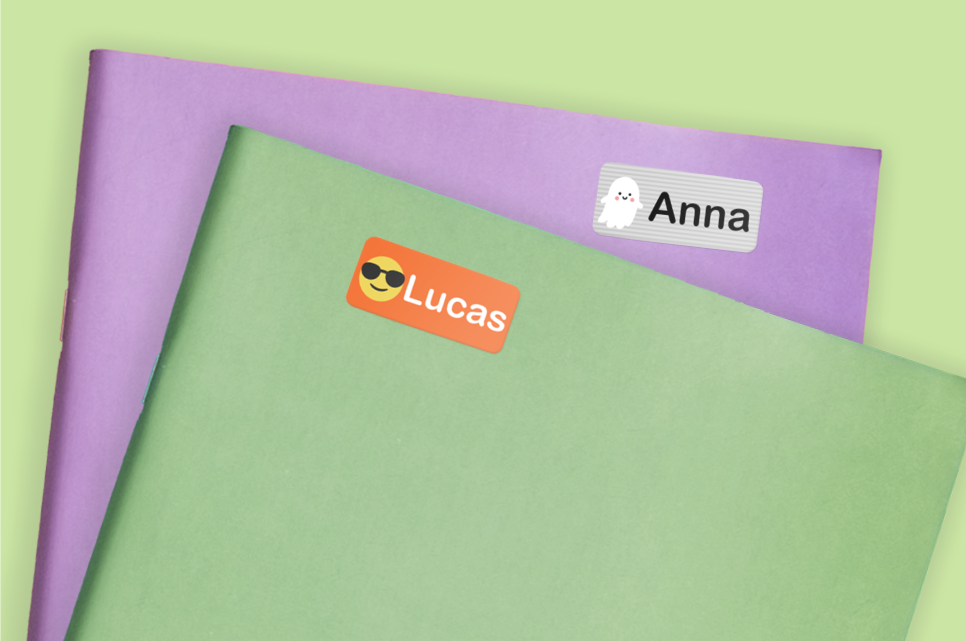 Close-up of two notebooks, one purple and one green, both labeled "Anna" and "Lucas".