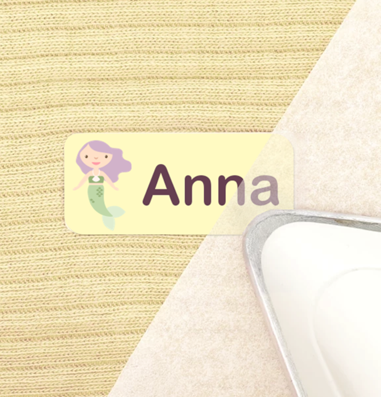 An iron is pressing a name label onto fabric.