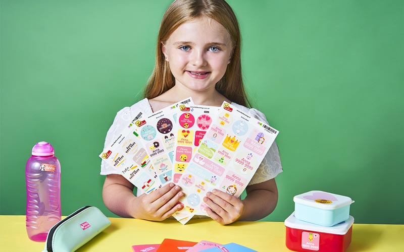 Girl holding sets of sticker name labels from My Nametags