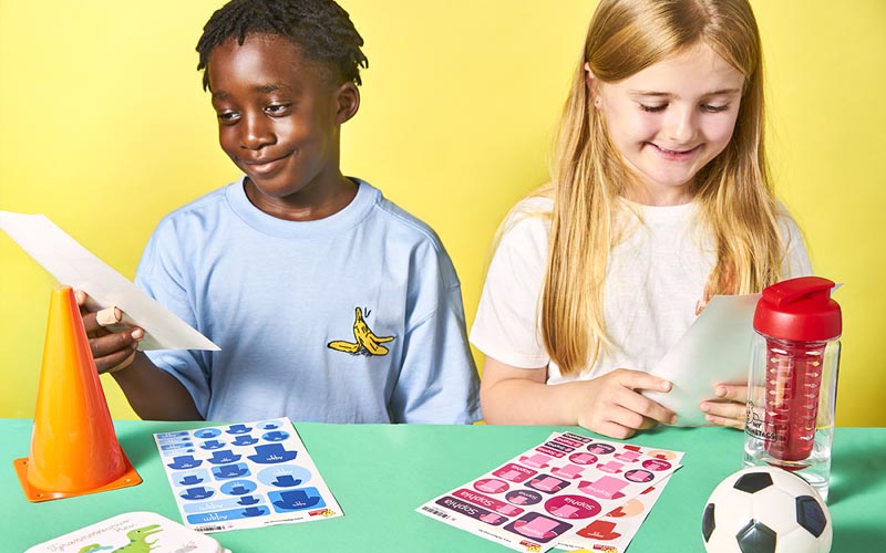 Two children looking at iron on name tags and name stickers from My Nametags