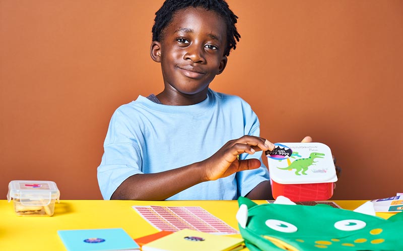 Name labels from My Nametags on a lunch box shown by a boy