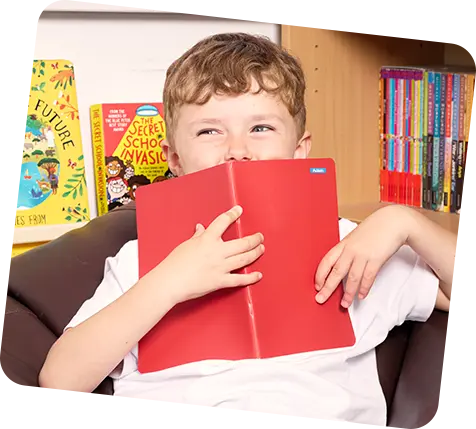 Child holding red book with ministicker on it